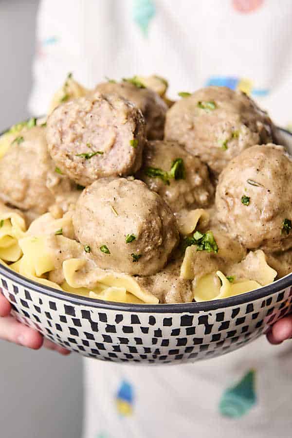 holding a bowl of noodles and swedish meatballs