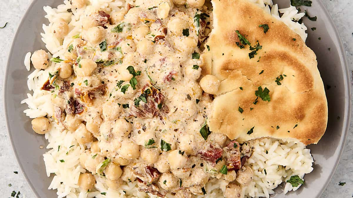 plate of vegan marry me chickpeas with rice and naan