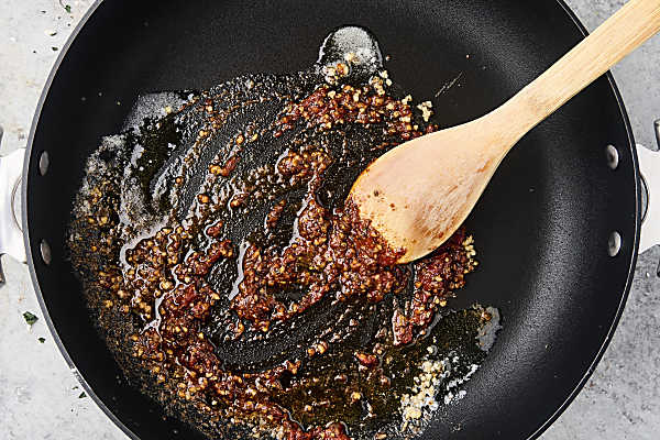 melted butter with tomato paste, garlic, and spices in a pan