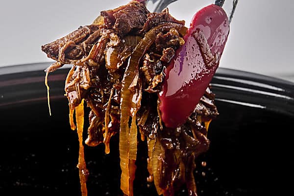 dunking shredded beef into juices