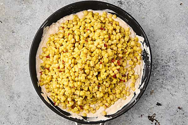 stirring corn into the dip