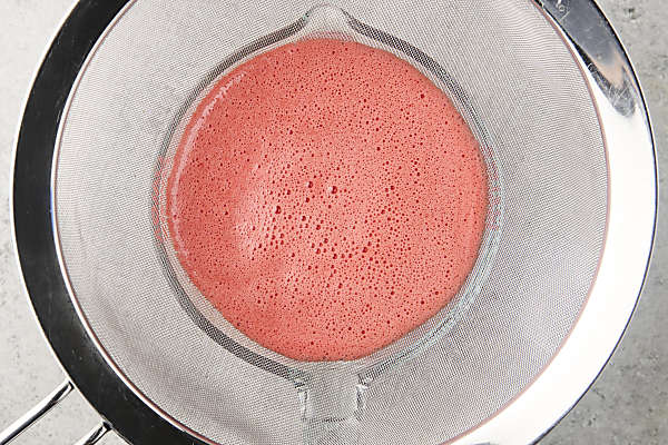 straining juice through a sieve