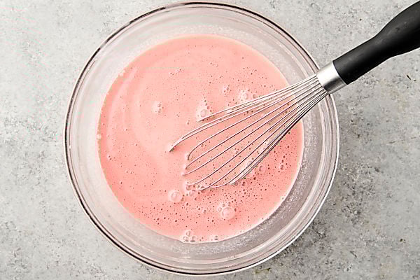 watermelon juice and sweetened condensed milk whisked together in a bowl