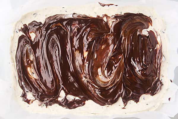 hot fudge spread on top of semi-frozen ice cream