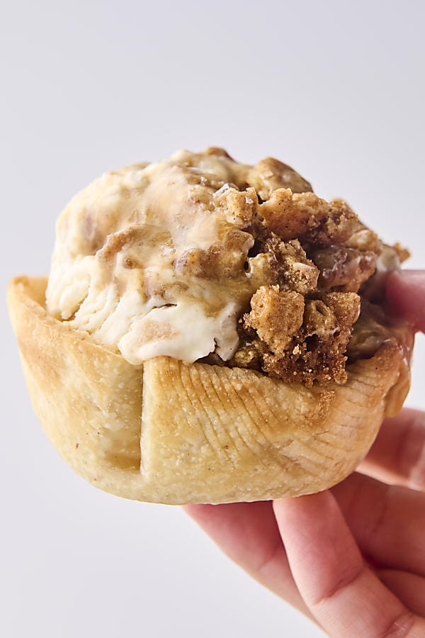 holding a pie crust bowl that's filled with no churn caramel apple ice cream