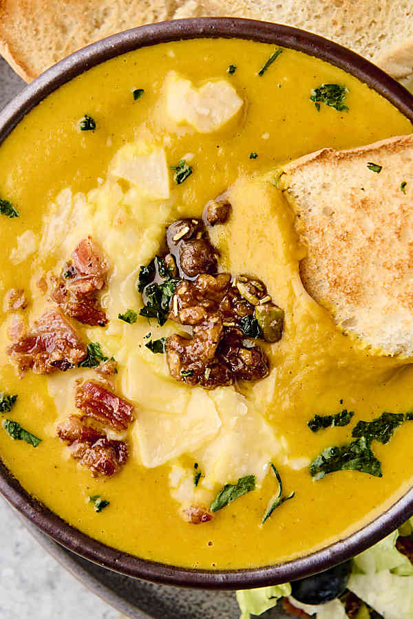 candied rosemary walnuts and pumpkin seeds on top of pumpkin soup