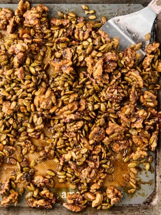 candied rosemary walnuts and pepitas on a baking sheet