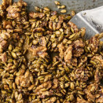 candied rosemary walnuts with pumpkin seeds on a baking sheet