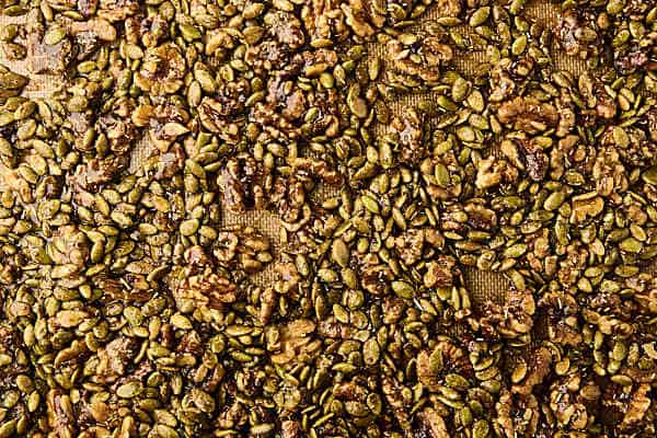 candied nuts and seeds on a baking sheet before baking