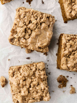 pieces of pumpkin crumb cake with maple glaze on parchment paper