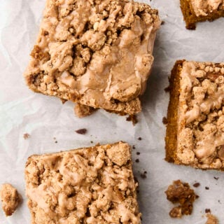 pieces of pumpkin crumb cake with maple glaze on parchment paper