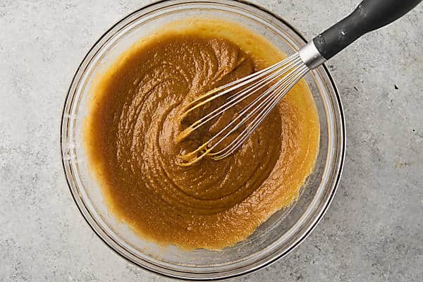 wet ingredients for a pumpkin crumb cake whisked together in a bowl