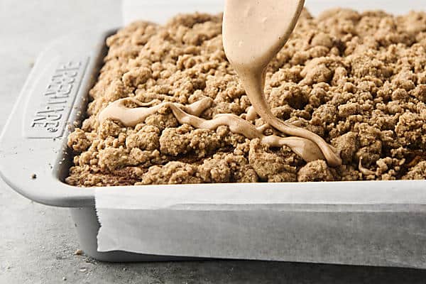 drizzling baked pumpkin crumb cake with glaze