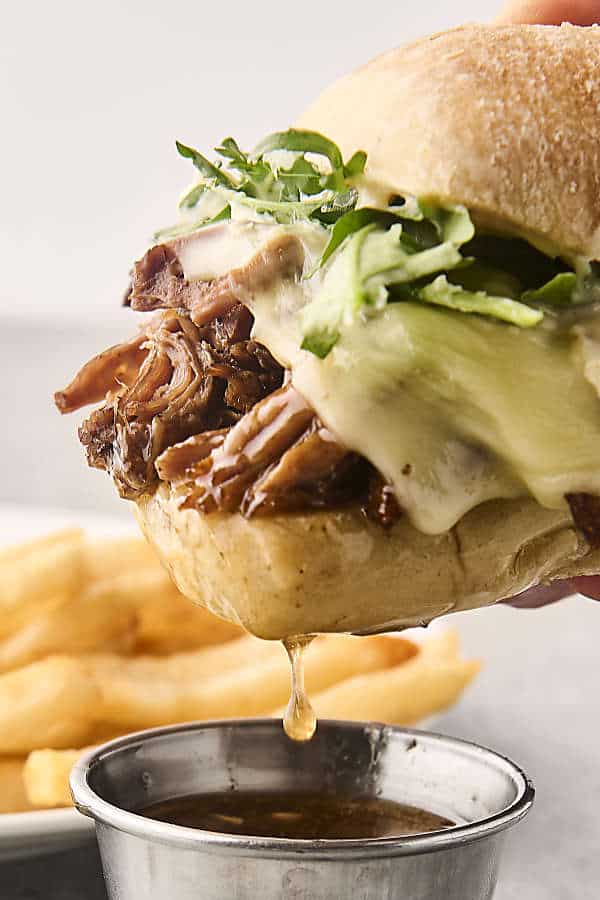 dunking a french dip sandwich in au jus