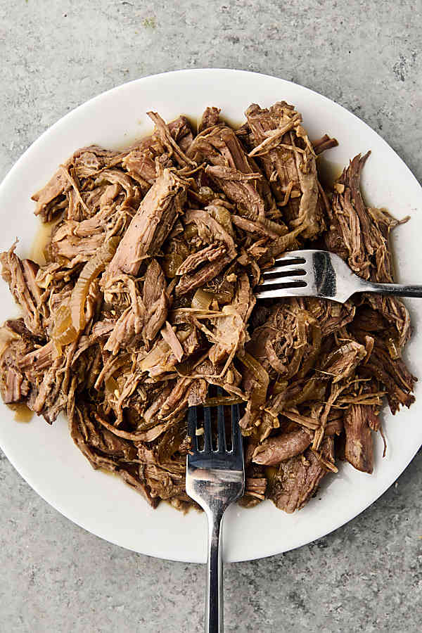 shredded chuck roast on a plate for french dip sandwiches