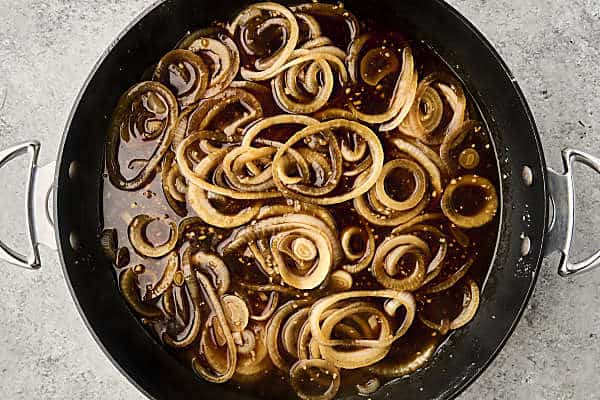 onions and garlic cooking in broth, worcestershire sauce, and au jus seasoning