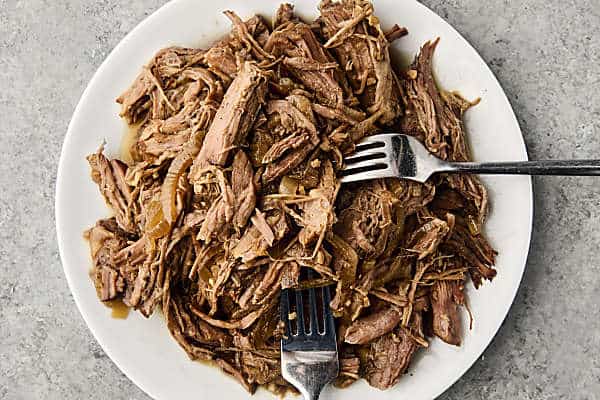 shredded beef for french dip sandwiches on a plate