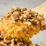 scoop of brown butter sweet potato casserole with rosemary walnut topping