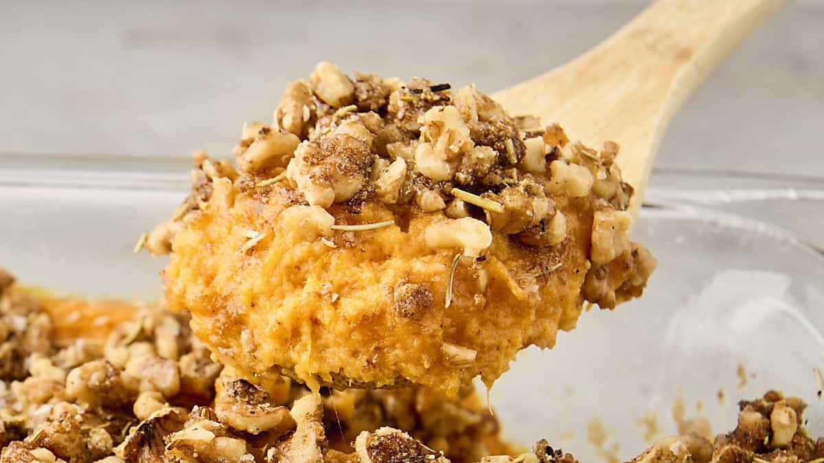 scoop of brown butter sweet potato casserole with rosemary walnut topping