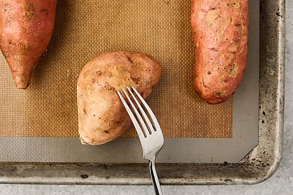 pricking sweet potatoes with a fork