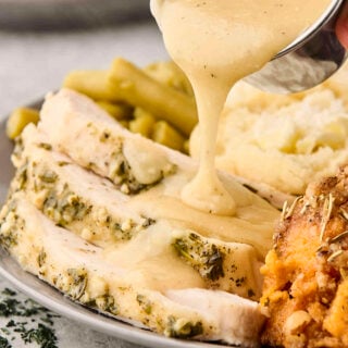 pouring gravy over sliced slow cooker turkey breast