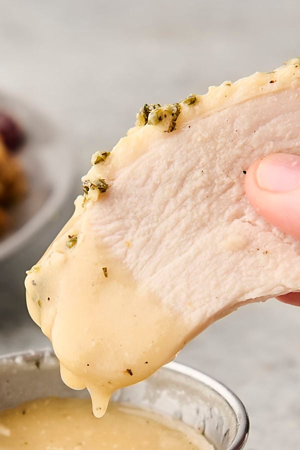 dunking juicy slow cooker turkey breast into gravy