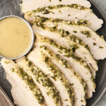 sliced slow cooker turkey breast on a plate with gravy