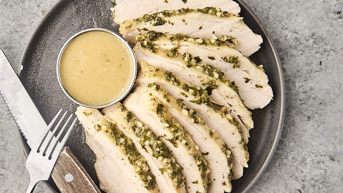 sliced slow cooker turkey breast on a plate with gravy