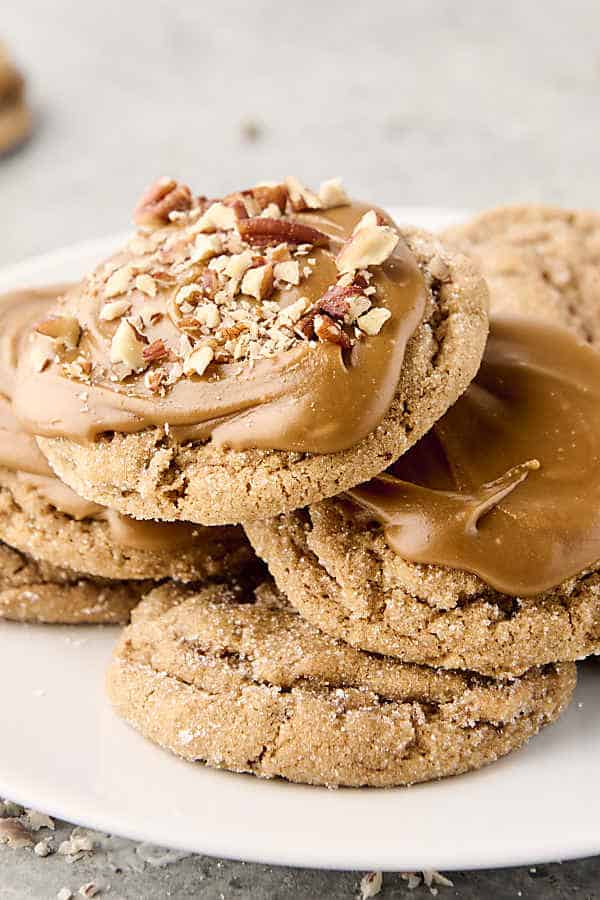 frosted brown sugar cookies stacked on a plate