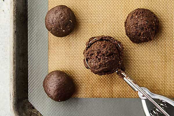 using a cookie scoop to scoop date bites into balls