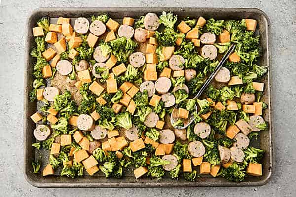 chicken sausage and veggies on a sheet pan before cooking