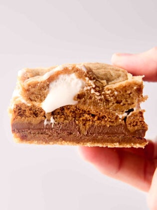 holding a biscoff cookie butter smores bar in hand