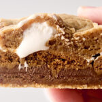 holding an gooey ooey cookie butter smores bar in hand