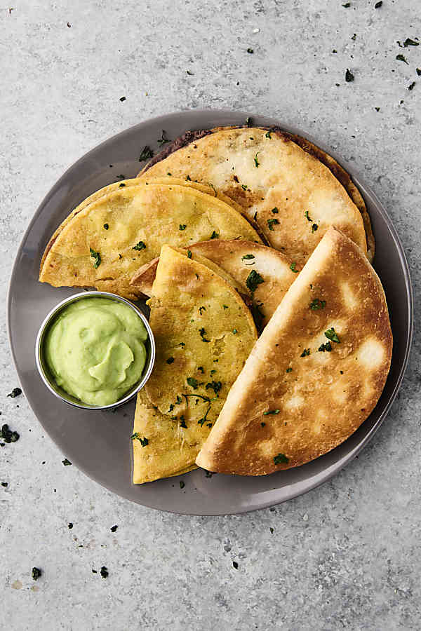 plate of crispy black bean tacos with avocado sauce