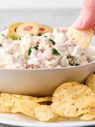 dipping a kettle chip into blue cheese and olive dip