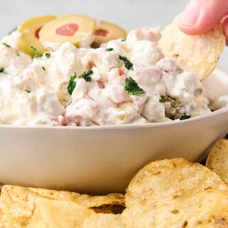 dipping a kettle chip into blue cheese and olive dip