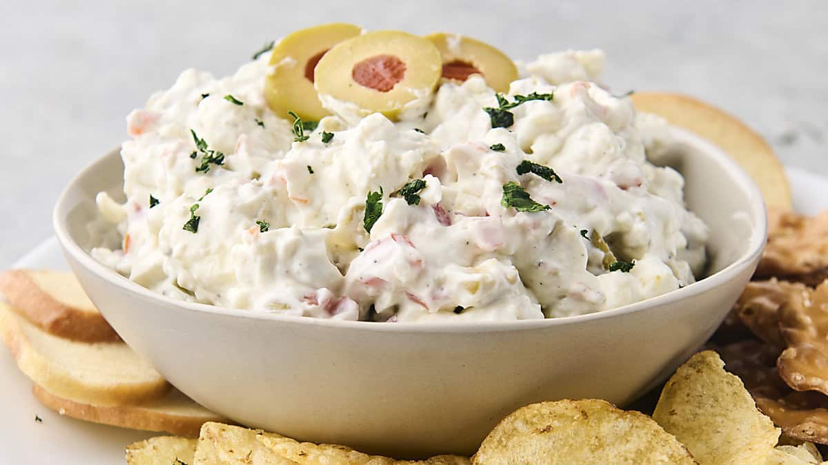 dirty martini dip in a bowl served with chips and pretzels