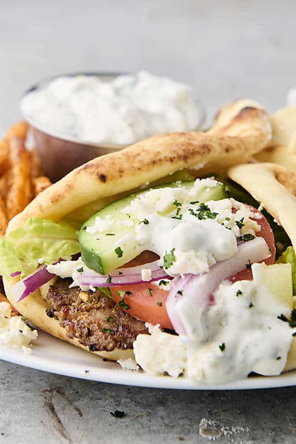 gyros on a plate with veggies and sauce