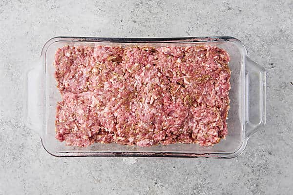 pressing gyro meat mixture into loaf pan