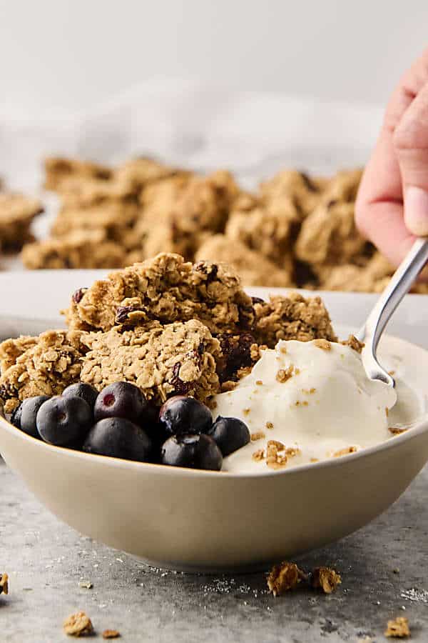 oatmeal cookie granola clusters in a bowl with yogurt and blueberries