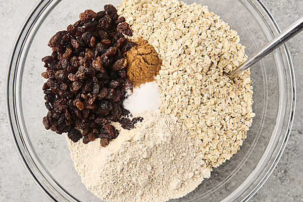 oats, ground oats, spices, and raisins in a bowl