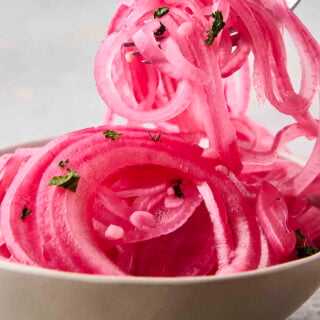 quick pickled red onions on a fork