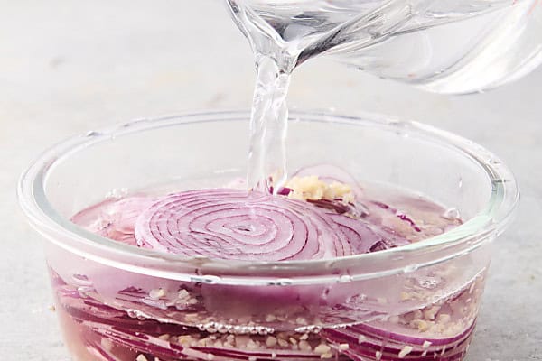 pouring vinegar mixture over onions