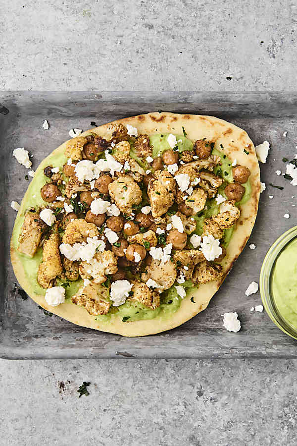 roasted veggie pita on a tray with avocado sauce