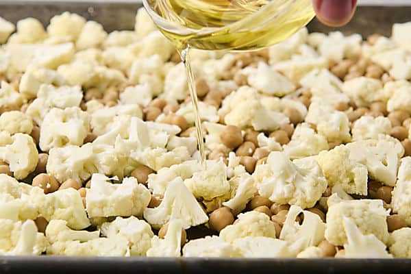 drizzling cauliflower and chickpeas with oil