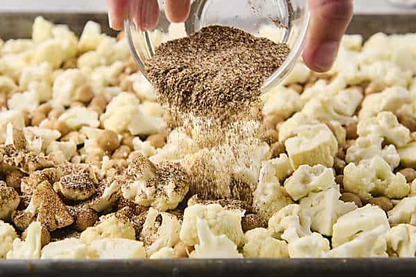 sprinkling cauliflower and chickpeas with spices