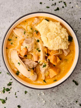 easy chicken stew with potatoes in a bowl topped with a biscuit