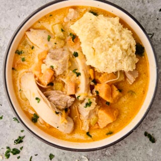 easy chicken stew with potatoes in a bowl topped with a biscuit