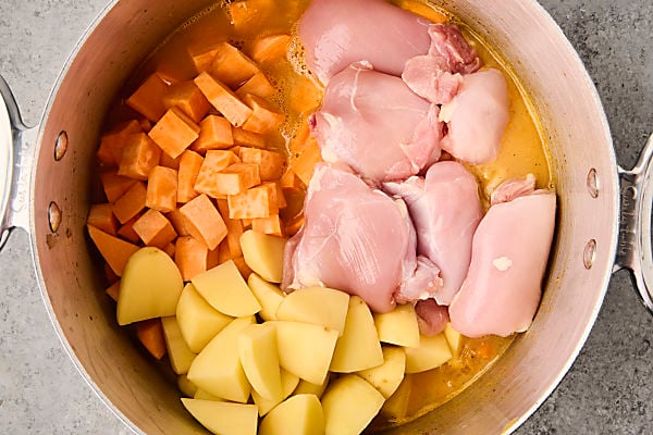 adding broth, chicken, and potatoes