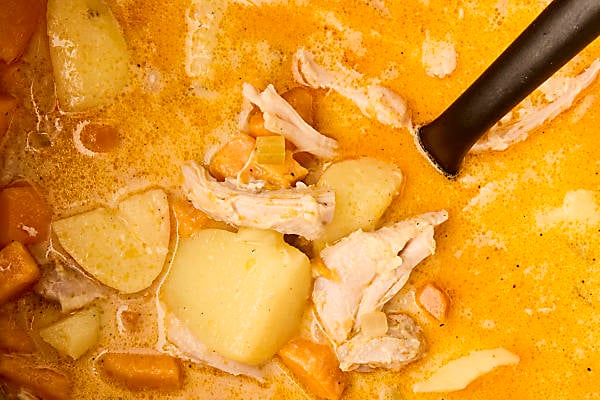 stirring half and half and shredded chicken into stew